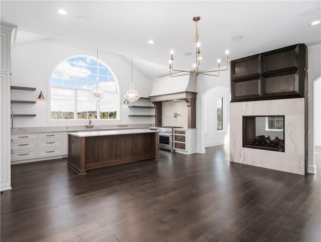 kitchen featuring open shelves, a chandelier, a kitchen island, light countertops, and open floor plan