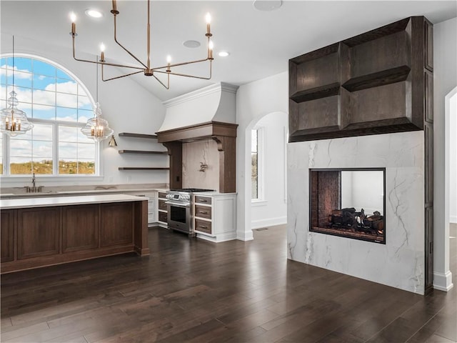 kitchen with open shelves, a chandelier, high end range, light countertops, and recessed lighting