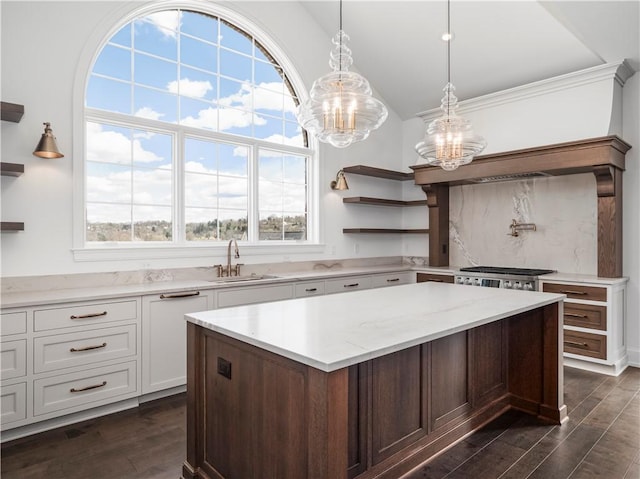 kitchen featuring a sink, a chandelier, open shelves, dark wood-type flooring, and a kitchen island