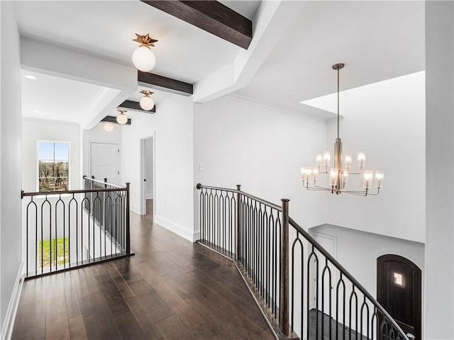 hallway featuring an upstairs landing, beamed ceiling, a chandelier, wood finished floors, and baseboards