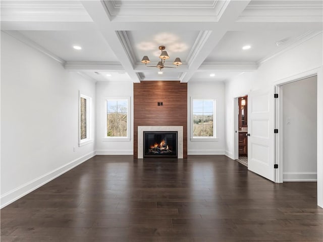 unfurnished living room with a chandelier, a glass covered fireplace, beamed ceiling, baseboards, and dark wood-type flooring