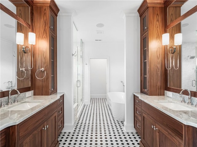 full bath featuring a stall shower, a soaking tub, baseboards, two vanities, and ornamental molding
