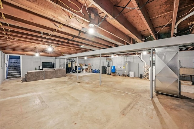 unfinished below grade area with stairway, electric water heater, and a water pressure tank