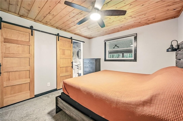 carpeted bedroom with a barn door, wood ceiling, and ceiling fan