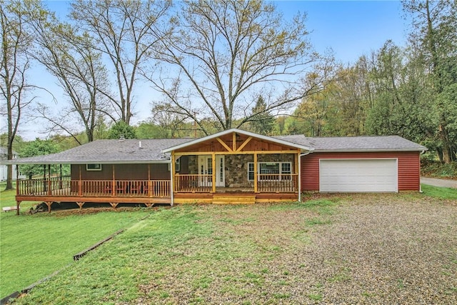 back of property with driveway, a garage, and a yard