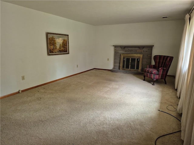 unfurnished living room featuring carpet flooring, baseboards, and a glass covered fireplace