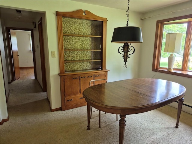 dining room featuring light carpet and baseboards