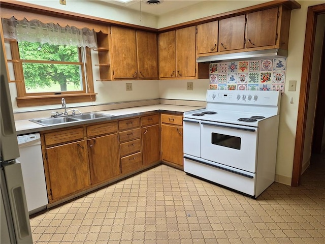 kitchen with white range with electric cooktop, a sink, under cabinet range hood, and light countertops