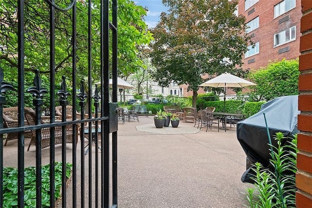 view of community with a patio area and fence