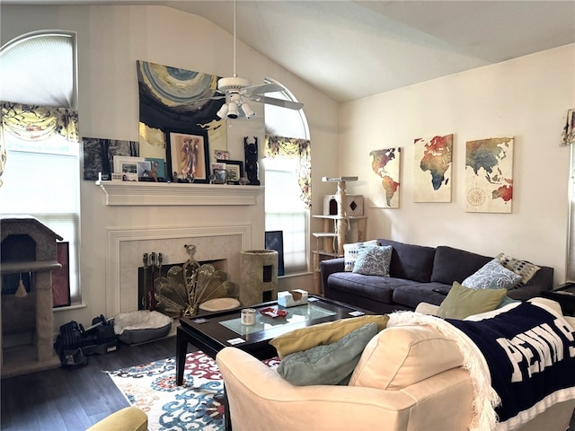 living room featuring wood finished floors, a tile fireplace, vaulted ceiling, healthy amount of natural light, and ceiling fan