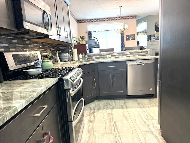 kitchen with stainless steel appliances, decorative backsplash, healthy amount of natural light, and a textured ceiling