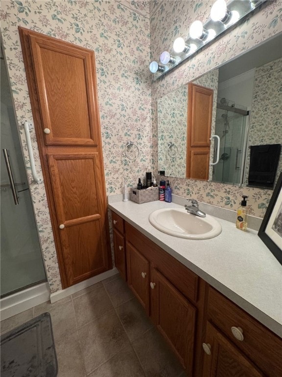 full bath with wallpapered walls, a shower stall, vanity, and tile patterned flooring