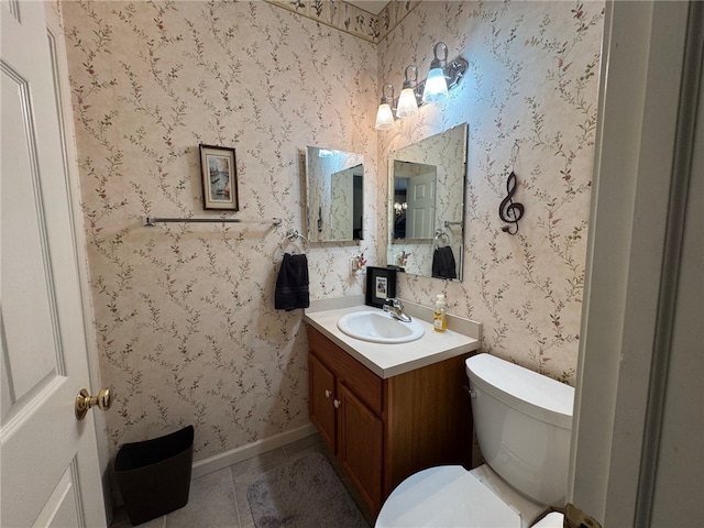 bathroom with toilet, tile patterned flooring, vanity, and baseboards