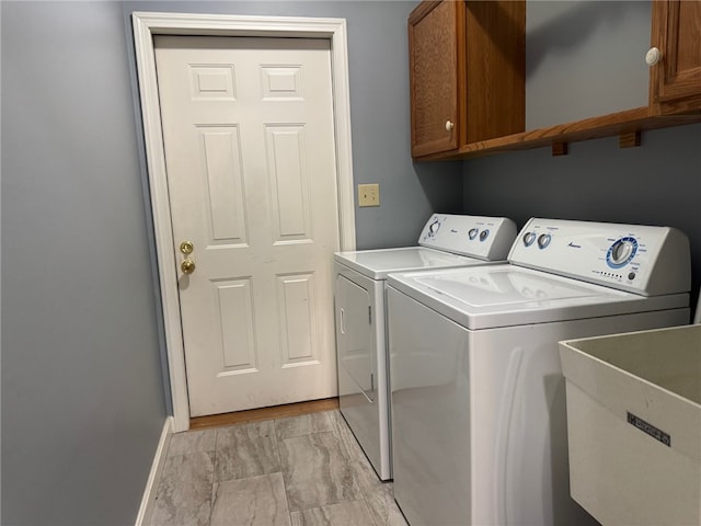 laundry area with cabinet space, washing machine and dryer, baseboards, and light marble finish flooring
