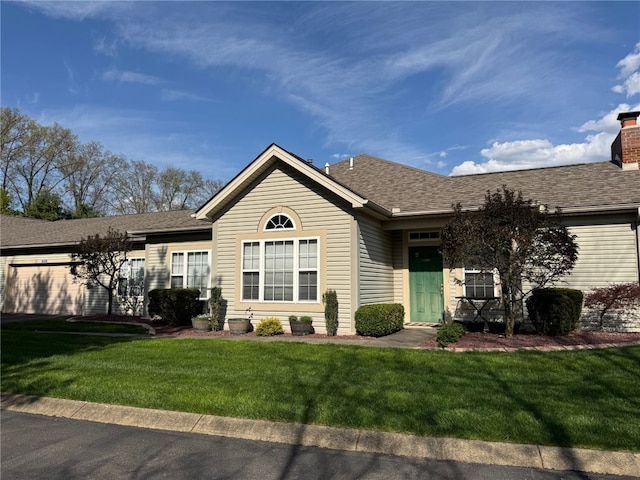 ranch-style home with a front yard, a chimney, and roof with shingles