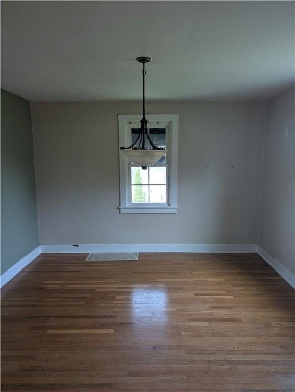 unfurnished dining area with baseboards and wood finished floors