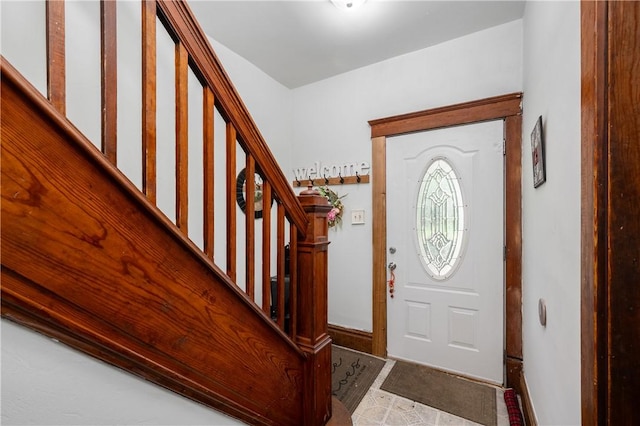 entrance foyer with stairway and baseboards
