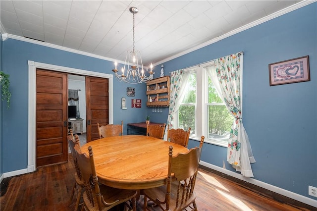 dining room with ornamental molding, hardwood / wood-style flooring, baseboards, and a chandelier