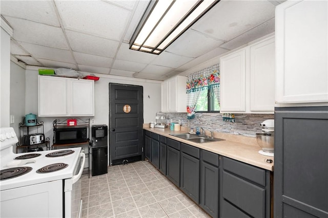 kitchen featuring electric stove, a sink, black microwave, white cabinetry, and gray cabinetry