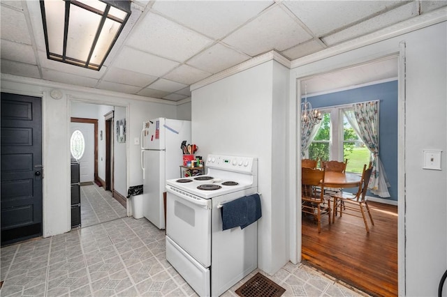 kitchen featuring white appliances, a chandelier, a paneled ceiling, baseboards, and ornamental molding