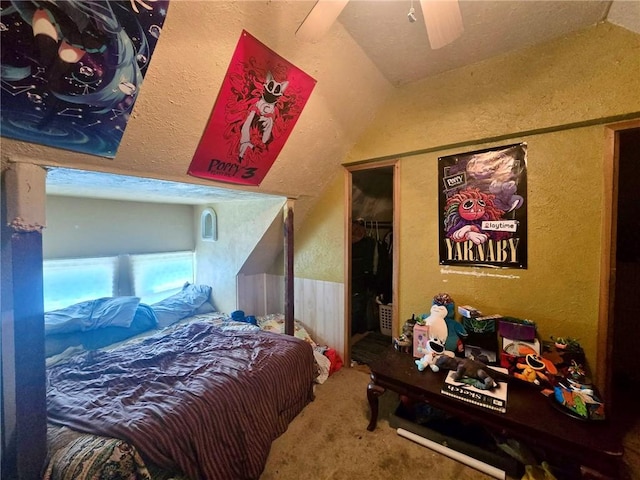 bedroom with vaulted ceiling, a textured wall, carpet flooring, a closet, and ceiling fan