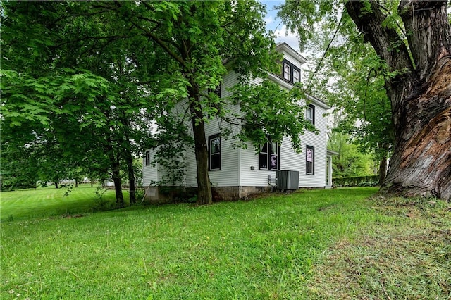 view of green lawn with central AC
