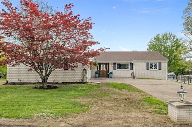 view of front of house featuring a front lawn and brick siding