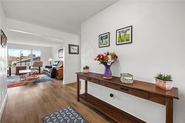 hall featuring wood finished floors and baseboards