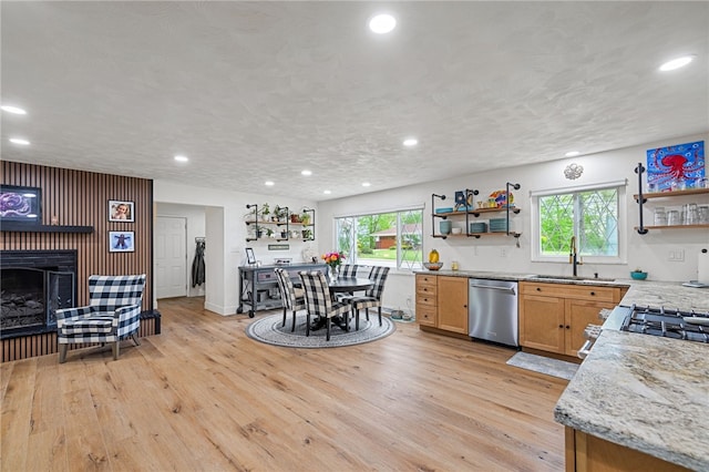 kitchen with open shelves, stainless steel dishwasher, a sink, light wood-style floors, and recessed lighting