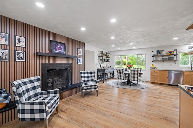 living area with light wood finished floors, a fireplace, recessed lighting, and healthy amount of natural light