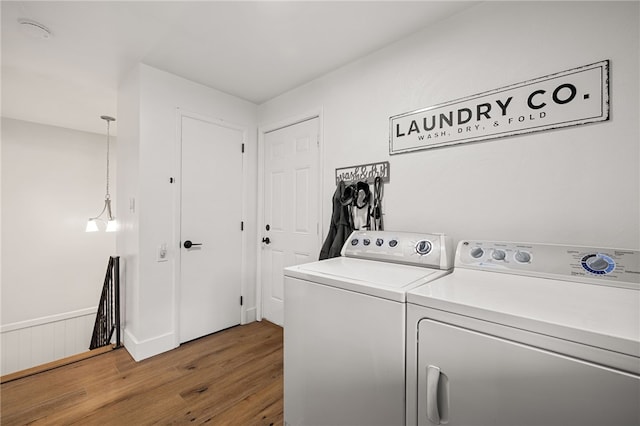 laundry room featuring washer and dryer and wood finished floors