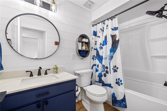 full bath with toilet, vanity, wood finished floors, and shower / bath combo