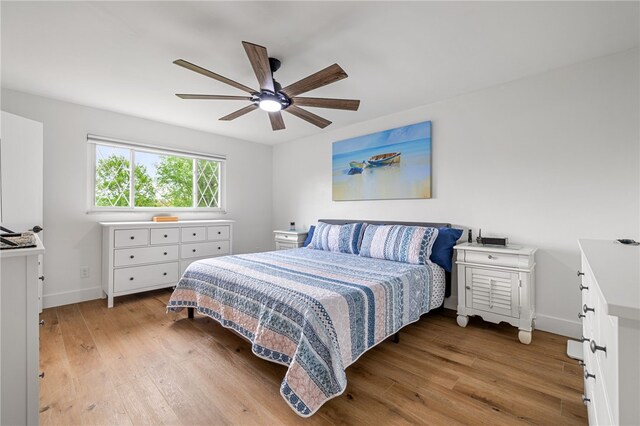 bedroom featuring light wood-style floors, baseboards, and a ceiling fan