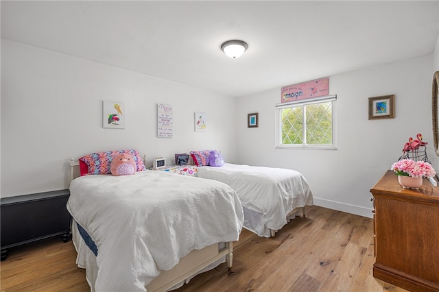 bedroom with light wood-type flooring and baseboards