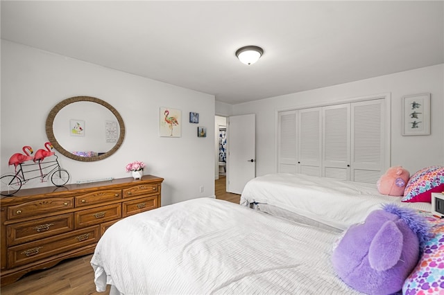 bedroom with wood finished floors and a closet