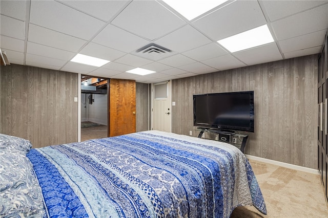 bedroom with wooden walls, a paneled ceiling, carpet floors, and baseboards
