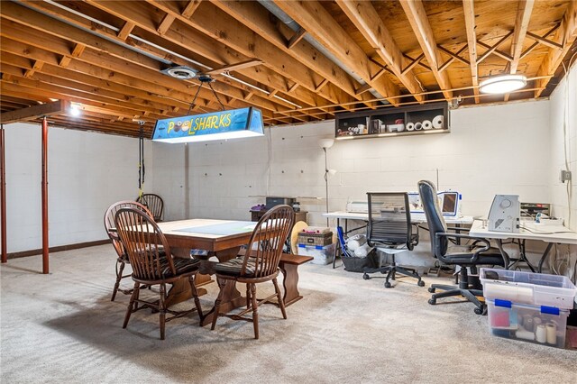 dining space with carpet floors and concrete block wall