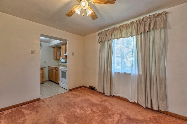 unfurnished room with ceiling fan, light carpet, baseboards, and a sink