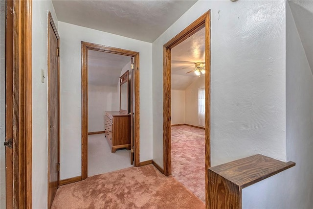 hall featuring light carpet and baseboards