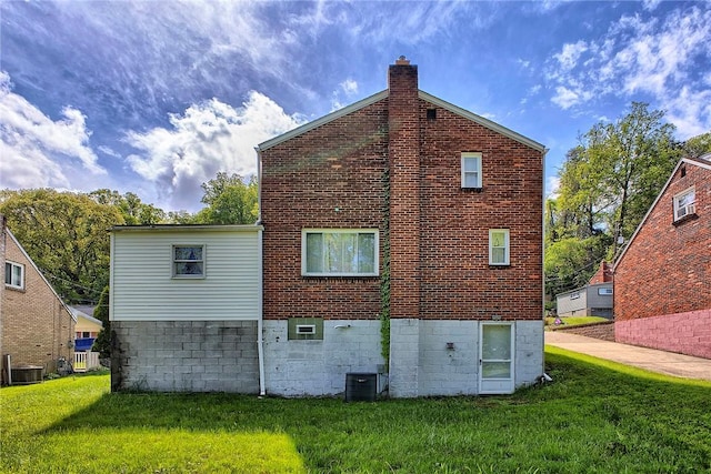 back of house featuring a yard, central AC unit, and a chimney