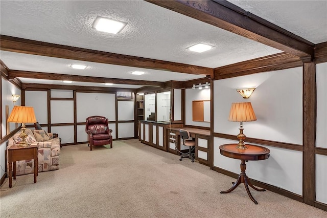 living area featuring a textured ceiling, carpet, beamed ceiling, and baseboards
