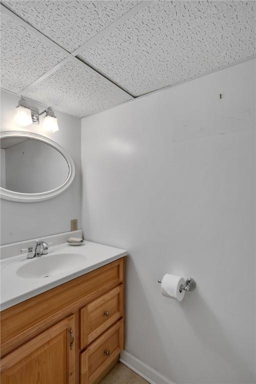 bathroom with vanity and a drop ceiling