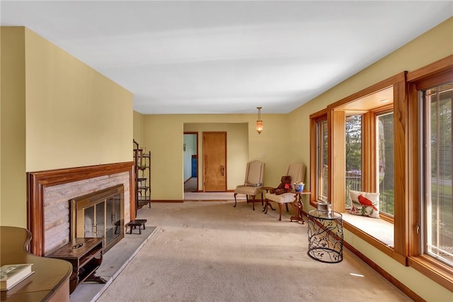 carpeted living room featuring baseboards and a fireplace