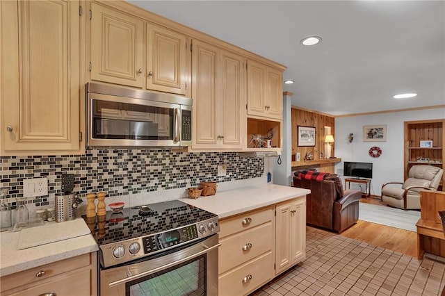 kitchen featuring stainless steel appliances, open floor plan, backsplash, cream cabinetry, and recessed lighting