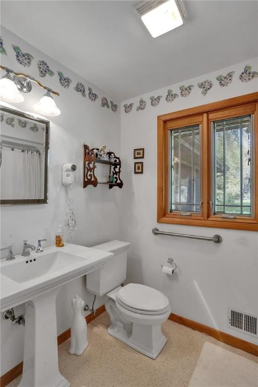 bathroom featuring baseboards and toilet