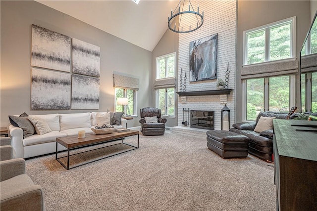 living room featuring high vaulted ceiling, carpet floors, a chandelier, and a fireplace
