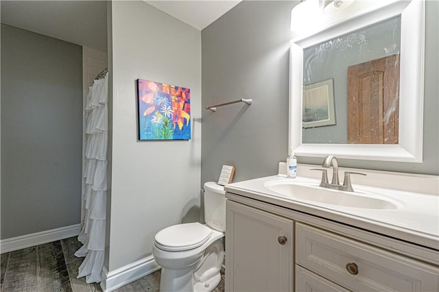 full bath with toilet, vanity, baseboards, and curtained shower