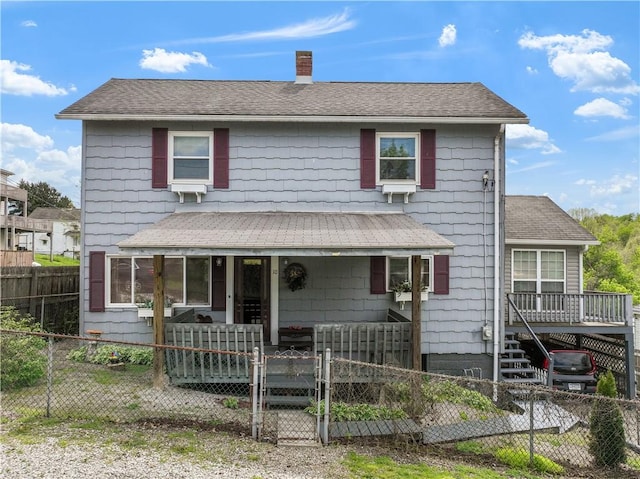 view of front of property with a gate, a chimney, a fenced front yard, roof with shingles, and covered porch
