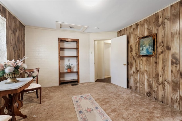 sitting room featuring wood walls, carpet floors, and ornamental molding