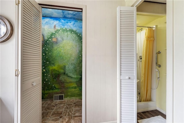 entryway featuring baseboards and wooden walls